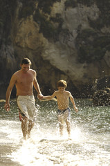 padre e figlio che corrono in spiaggia