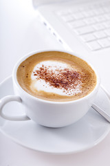 Cappuccino vor Laptop