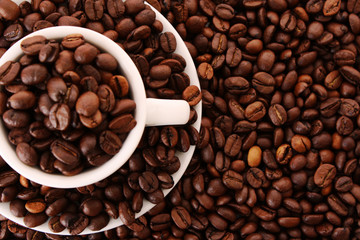 Small white cup of coffee with coffee grain on grain background