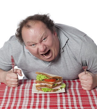 homme enrag&eacute; mangeant un sandwich