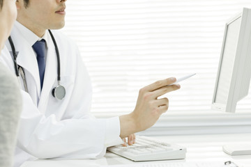 モニタで患者に説明する医者