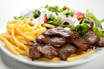 Grilled meat with fried potatoes and vegetables