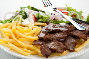 Grilled meat with fried potatoes and vegetables
