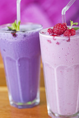 Two fruit smoothie drinks with fresh fruit