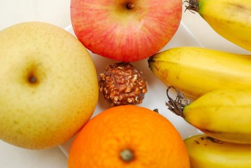 Unhealthy chocolate surrounded by healthy fruits