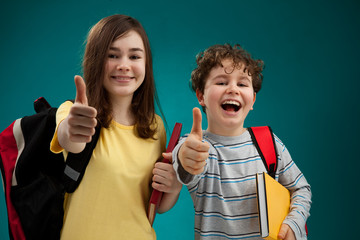 Students with backpack showing OK sign