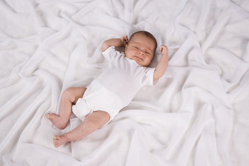 One month old baby boy lying on blanket asleep