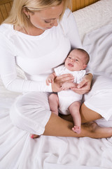 Obraz na płótnie Canvas Mother holding baby boy in her arms