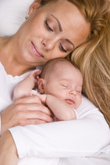 Fototapeta na wymiar Mother holding baby boy asleep in her arms