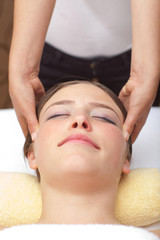 Fototapeta na wymiar Young woman receiving head massage