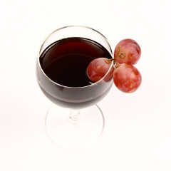 Red wine with three red grapes on white background
