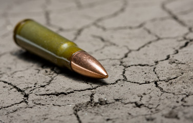 Kalashnikov bullet on desert land background