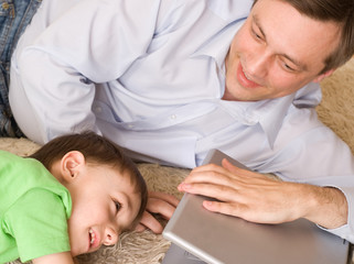 father playing with  son with laptop