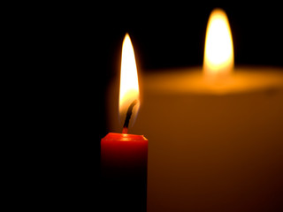 Two candles flaming in the dark