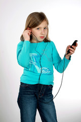 Młoda dziewczyna słucha muzyki na odtwarzaczu mp3. - obrazy, fototapety, plakaty