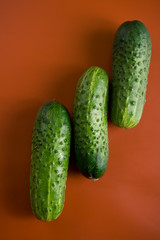three green bumps cucumbers on a red background