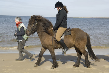 Two equestrians on horseback on the beach