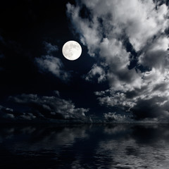 Moon and clouds above sea at night