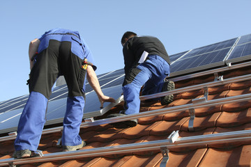 Workmen are mounting solar paneels