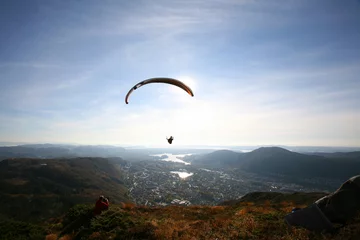 Papier Peint photo Sports aériens Parapente survolant le paysage côtier norvégien
