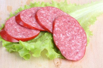 long loaf of smoked sausage lies on chopping board