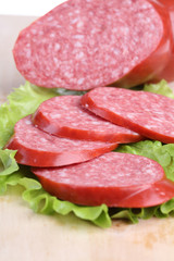 long loaf of smoked sausage lies on chopping board