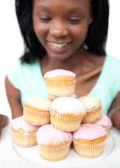 Smiling young woman looking at cakes