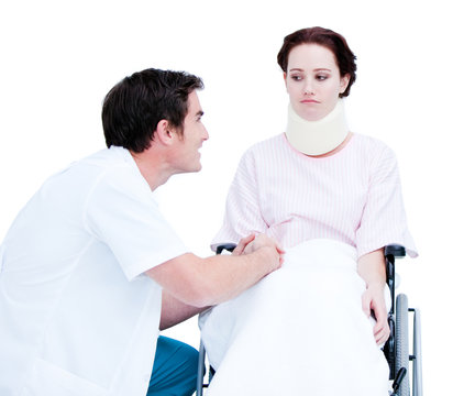 Attentive male doctor discussing with a patient in a wheelchair