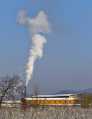 Fototapeta na wymiar Smoke from a boiler-house pipe in the frosty morning
