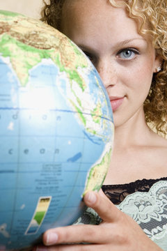 Young woman holding globe