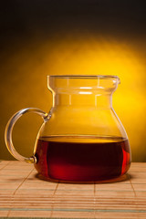 Glass teapot on a golden background