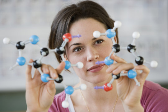Hispanic woman holding molecular model