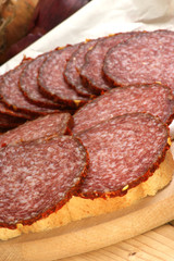 aufgeschnittene Salami auf einem Holzbrett