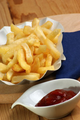 Pommes frites in einer Pappschale mit Ketchup
