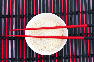 Light rice in a bowl in chopsticks