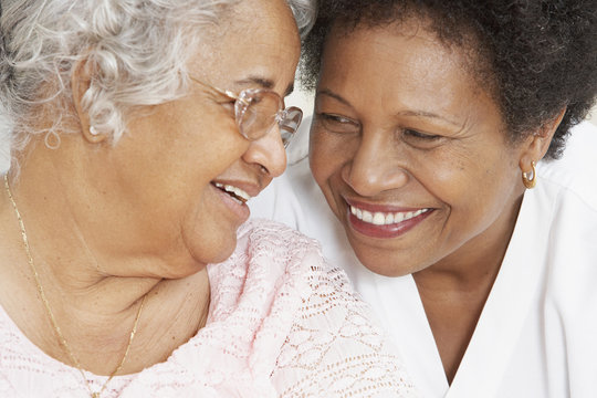 African American mother and adult daughter smiling at each other