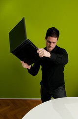 Frustrated man trashing laptop