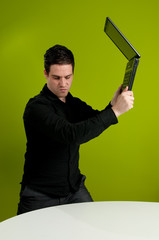 Frustrated man trashing laptop