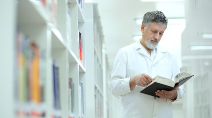 Naklejka na ściany i meble Renowned scientist/doctor in a library of research center/hospit