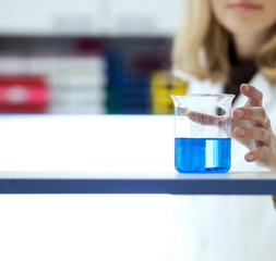 female researcher carrying out research/experiments in a chemist