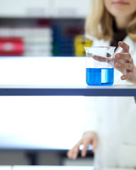 female researcher carrying out research/experiments in a chemist