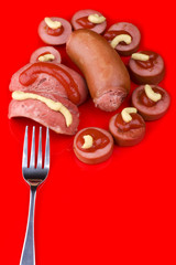 Cutting sausage on red background
