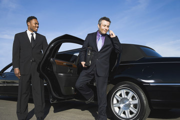 Hispanic businessman getting out of limousine
