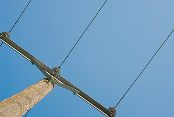 Electric wires and wooden pole on blue sky