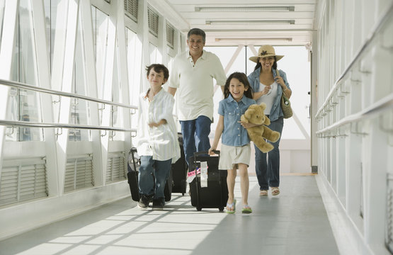 Hispanic family walking through airport