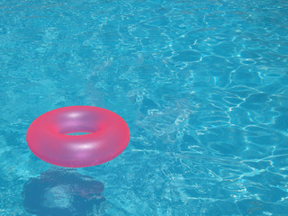 Pink Lifebuoy floating in pool