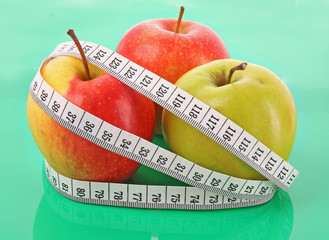 White tape measure around a red apple representing dieting