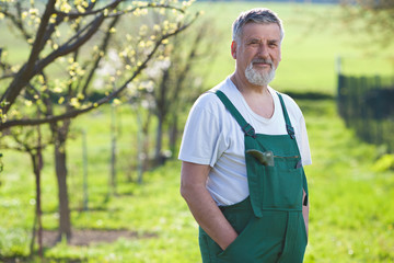 Portrait of a senior man gardening in his garden