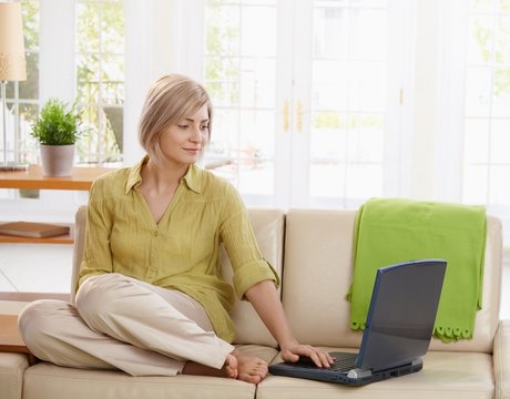 Woman using computer on couch