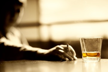Smoking man with a glass of whisky and cigar